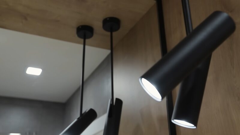 Sleek, Modern Black Pendant Lighting Fixtures Hanging from A Wooden Ceiling, Illuminating a Contemporary Room Design